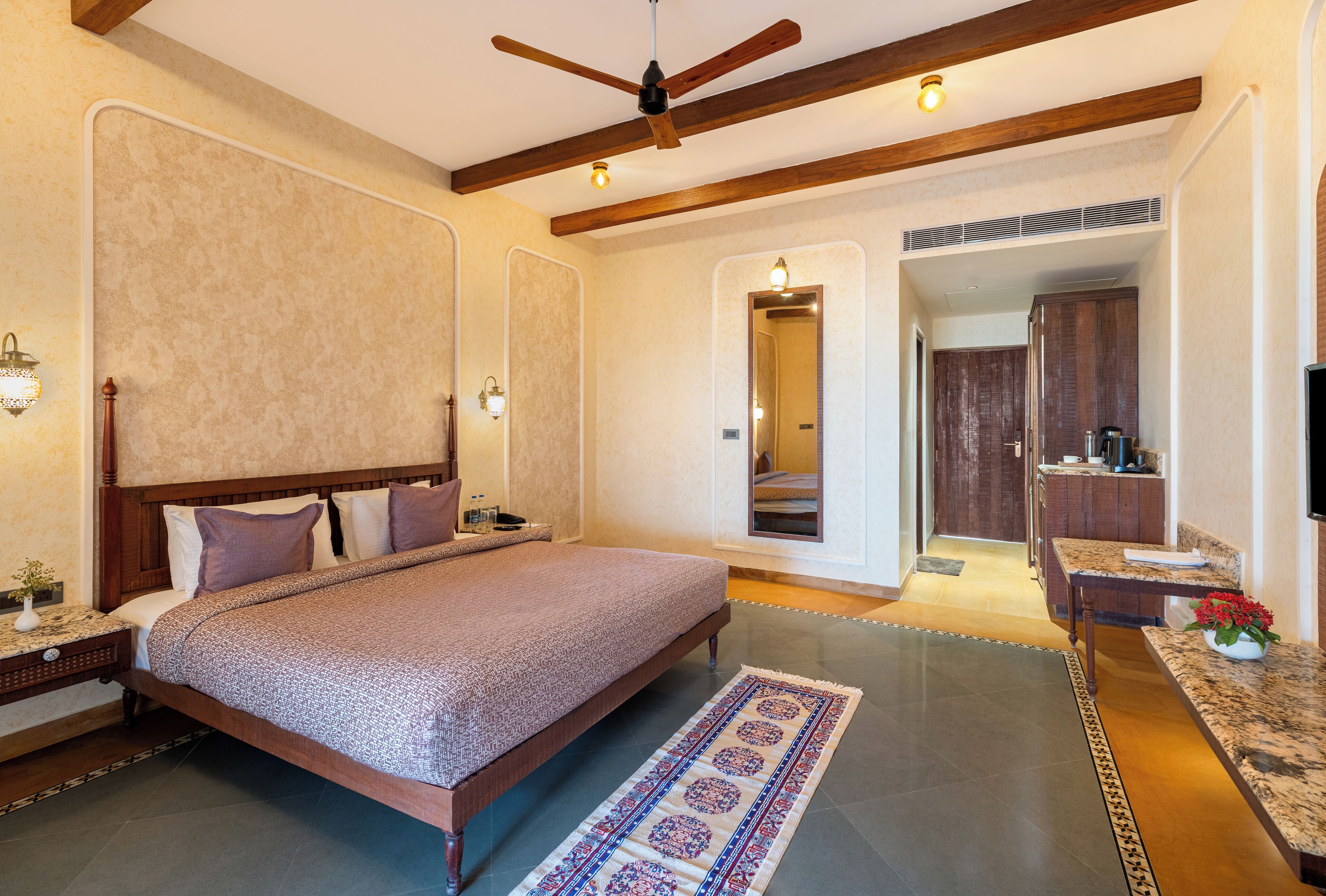Un dormitorio amplio con una cama grande, cabecera de madera y ventilador de techo.