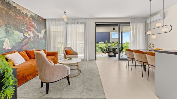 A modern living room with a sofa, armchairs, a coffee table, and a dining area with chairs and a table. There is a large window with curtains, a painting on the wall, and an air conditioning unit on the wall. - The Adriatic - Luxury Waterfront Apartment (Zadar)