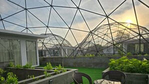 A rooftop garden with artificial grass, a seating area with wicker chairs and a table, and a large geodesic dome structure in the background. - The Ten Poolvilla Huahin (Hin Lek Fai)