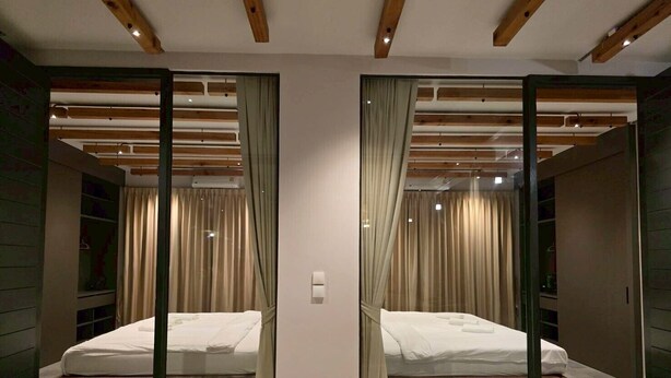 A mirrored room with a bed, curtains, and a wooden ceiling. - The Ten Poolvilla Huahin (Hin Lek Fai)