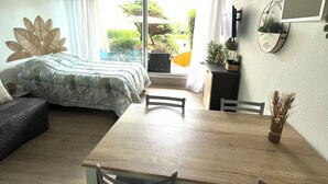 Un dormitorio moderno con una cama grande, una mesa de comedor y un ventilador de techo.