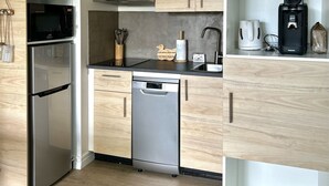 Una cocina moderna con gabinetes de madera, electrodomésticos de acero inoxidable y un colgante de luz.