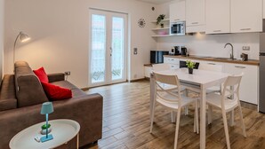 A modern apartment with a living area, a dining table, and a kitchen.