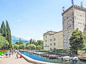 Un bâtiment historique doté d’une tour, un canal où naviguent des bateaux et un parc où l’on peut se promener.