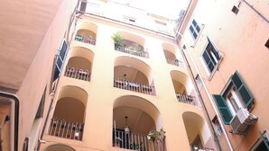 A multi-story building with balconies, air conditioning units, and arched windows.