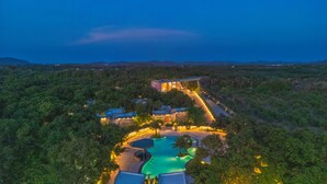 Ein Resort mit Schwimmbad, mehreren Gebäuden und einer bewaldeten Landschaft.