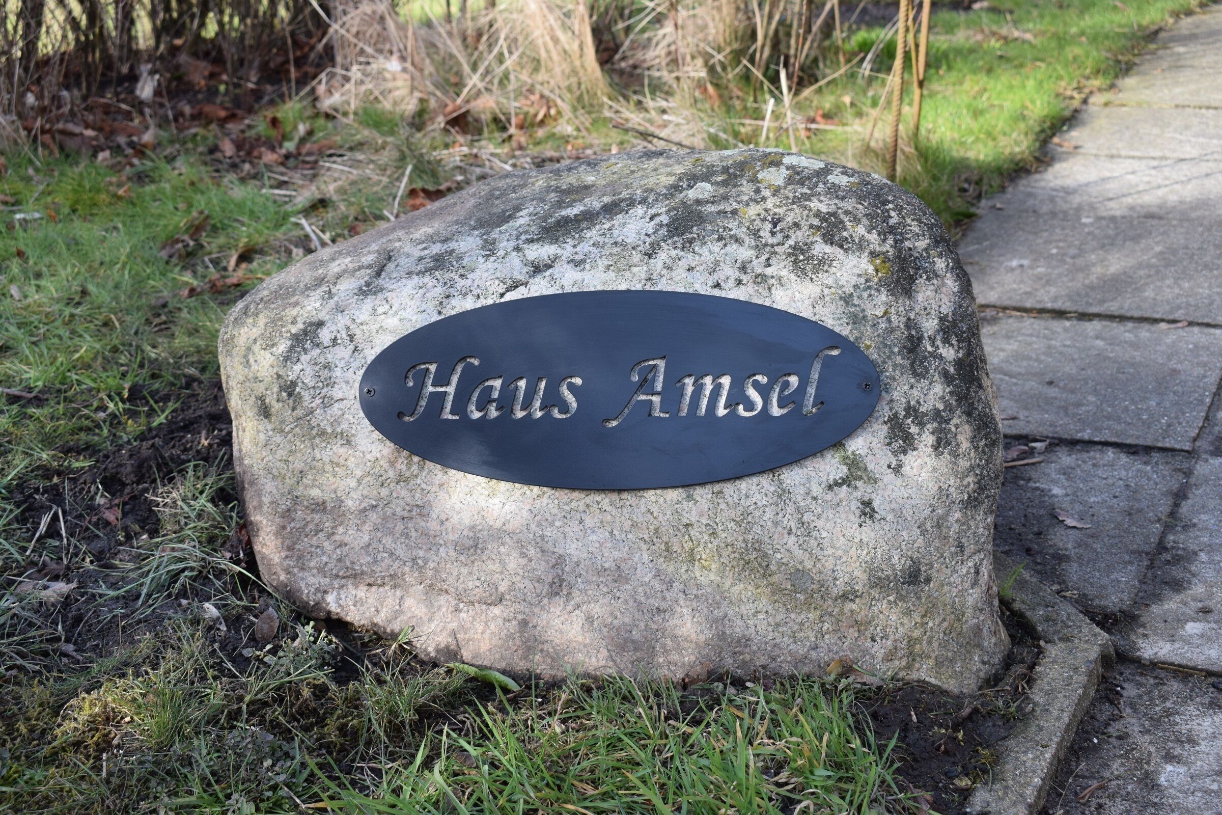 Une pierre sur laquelle est gravée une inscription indiquant « Haus Amsel ».