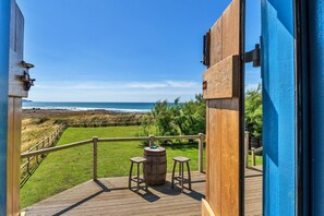 Eine Holzterrasse mit Blick auf den Strand und den Ozean.