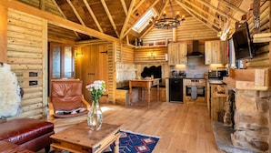 Ein Blockhaus-Interieur mit Essbereich, Küche und Wohnzimmer.