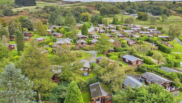 A cluster of wooden cabins surrounded by lush greenery and hills. - Log Cabin in Snowdonia near Rhinog Mountains (Trawsfynydd)
