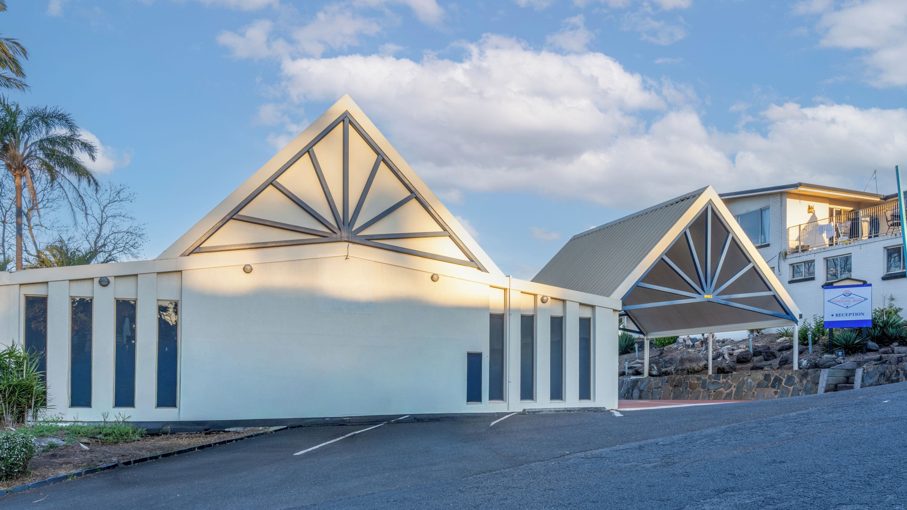 Un edificio moderno con un design del tetto a forma triangolare e un’area reception.