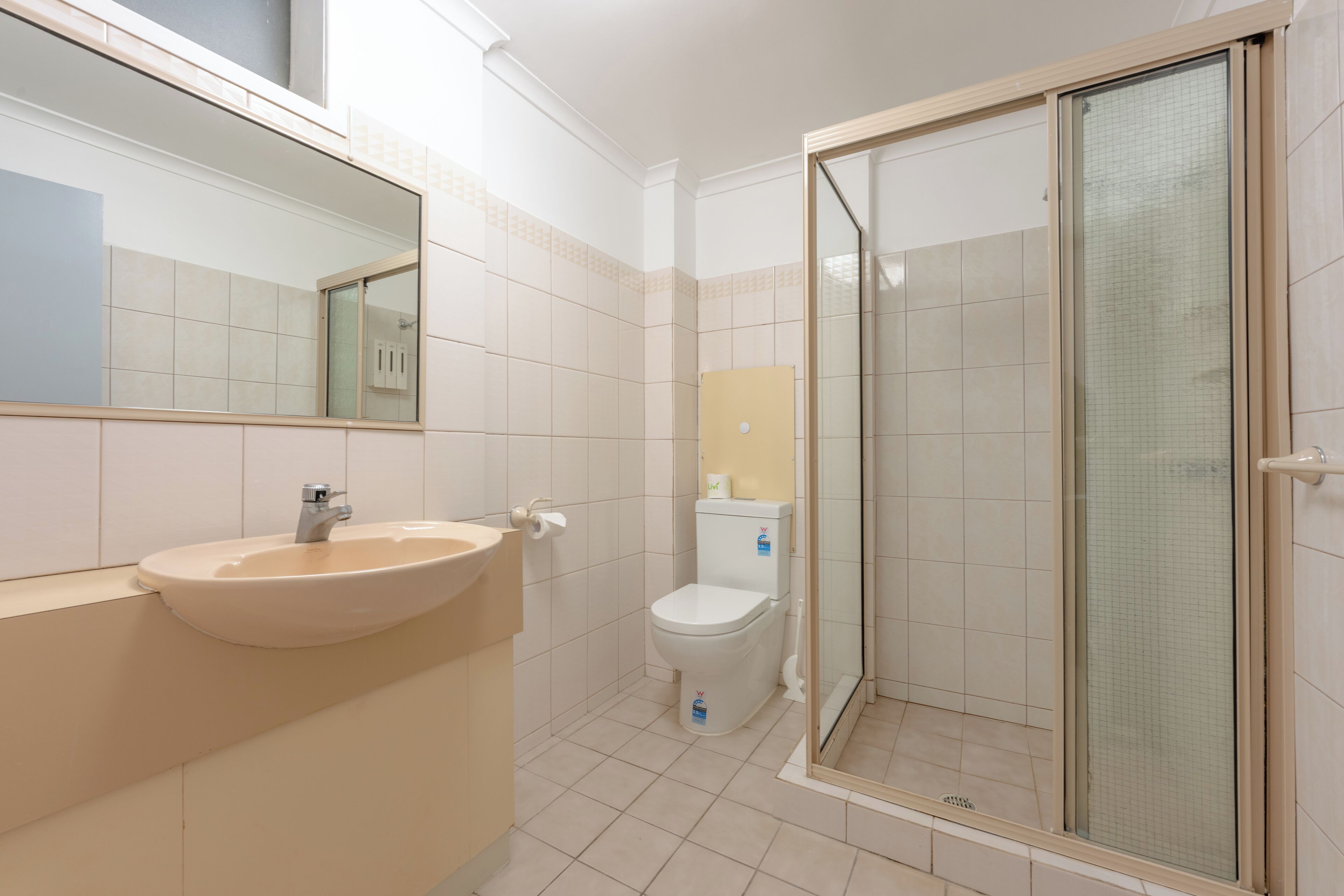 A bathroom with a sink, toilet, and glass-enclosed shower.