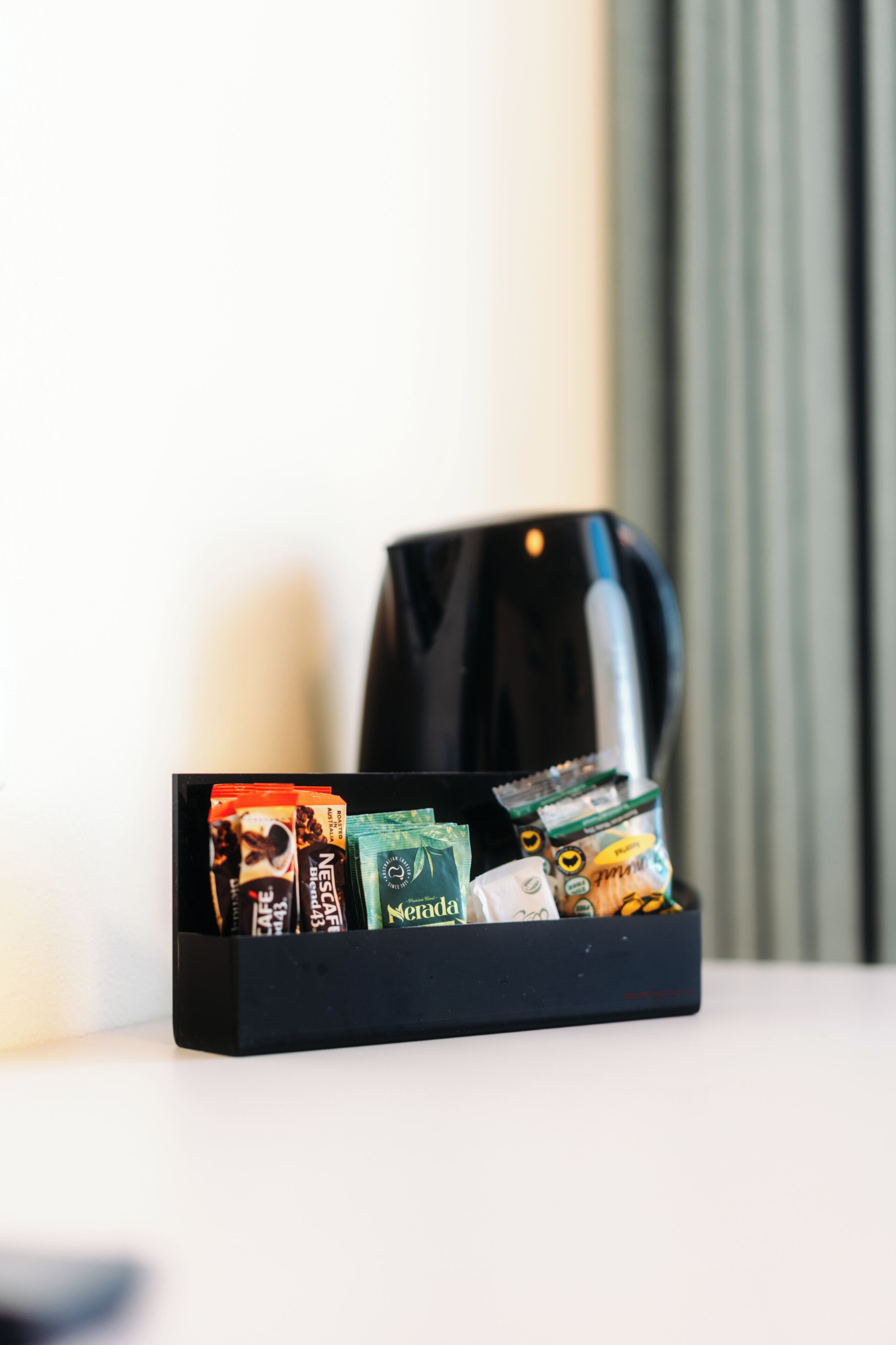 Una cafetera con un portacápsulas de café que contiene varias marcas.