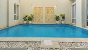 A swimming pool with decorative panels and potted plants. - Omah Manis Taman Siswa (Yogyakarta)