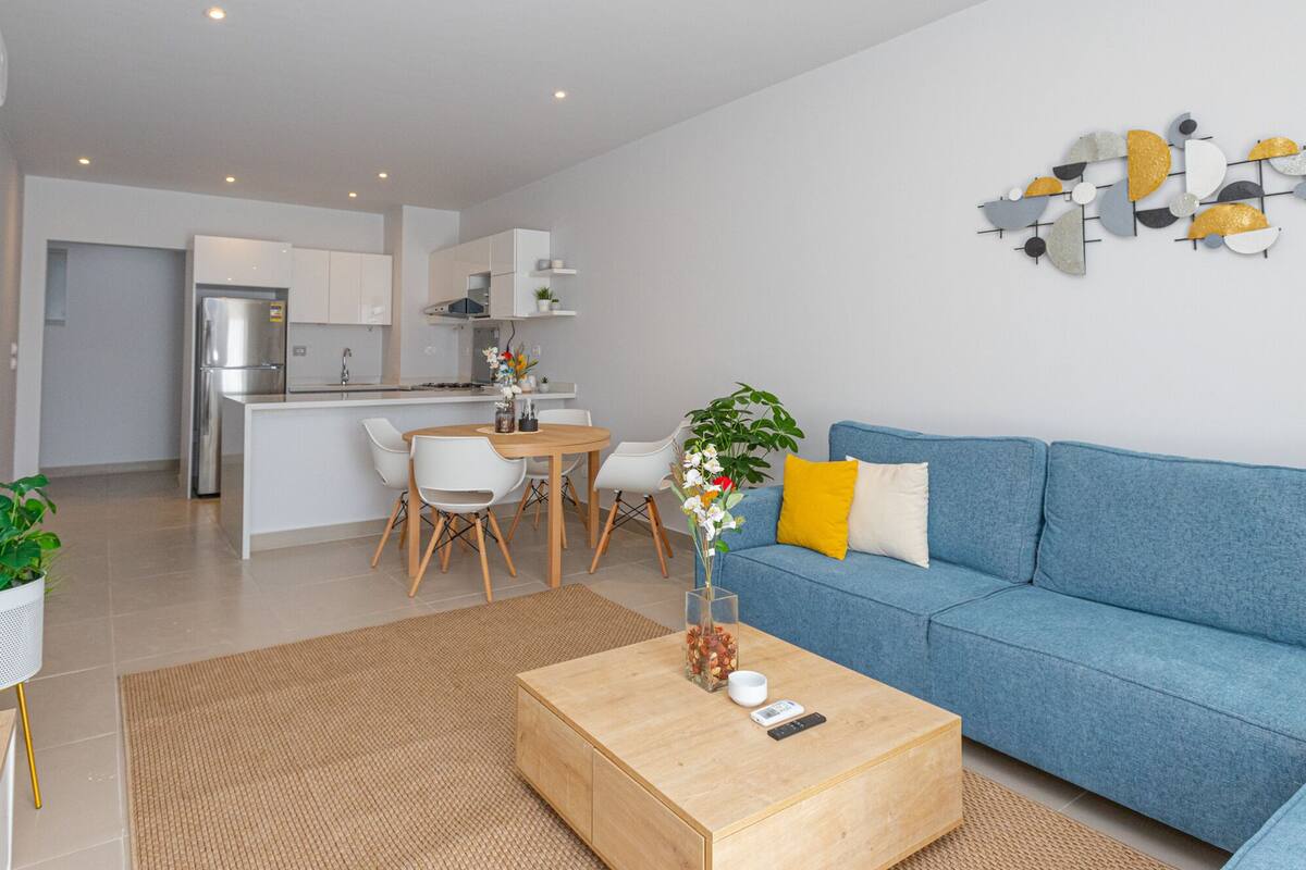 A modern apartment with a kitchen, dining area, and living room.