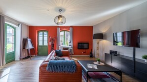 Uma sala de estar moderna com sofá, mesa de centro e televisão.