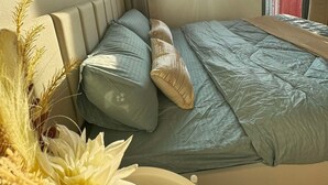 A compact bedroom with a single bed, a window with blinds, and a view of buildings outside. - Stunning skyline views in Makati (Makati)
