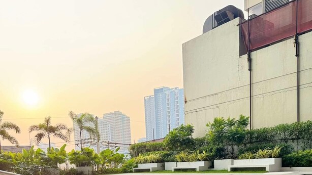 A swimming pool with clear water, surrounded by greenery and modern buildings in the background. - Stunning skyline views in Makati (Makati)