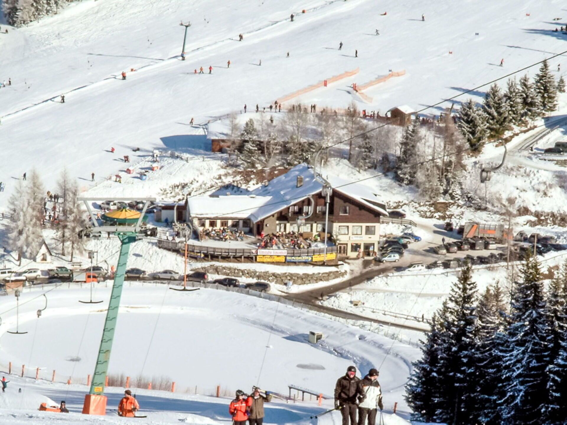 Een wintersportgebied met een lodge, skiliften en een besneeuwd landschap.