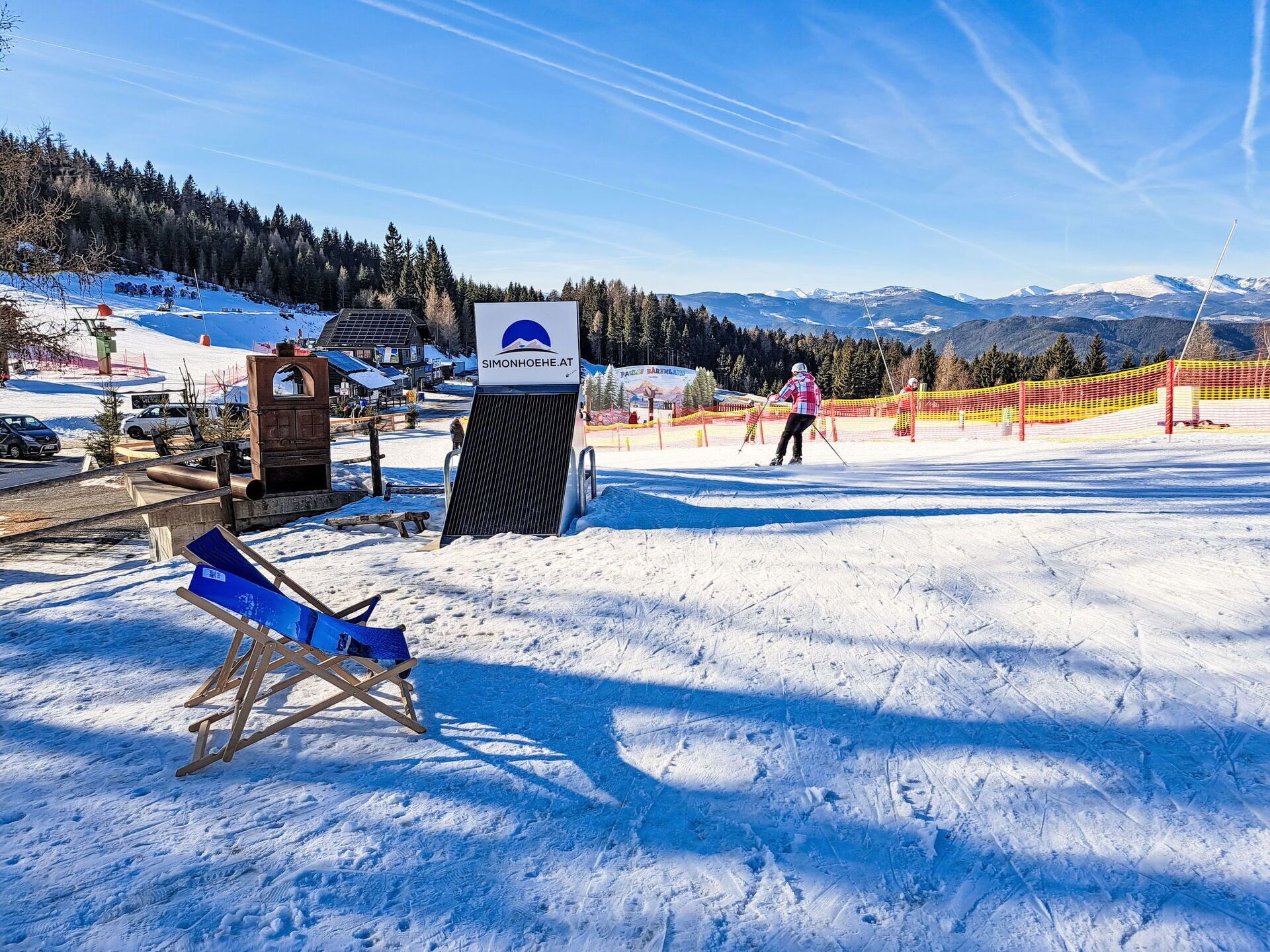 Une station de ski équipée d'un télésiège, d'une piste de ski et d'un panneau indiquant l'adresse Simonhoehe.at.