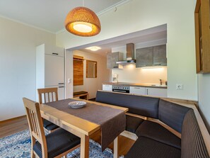 Una cocina compacta con zona de comedor, que incluye una mesa con sillas y un banco.