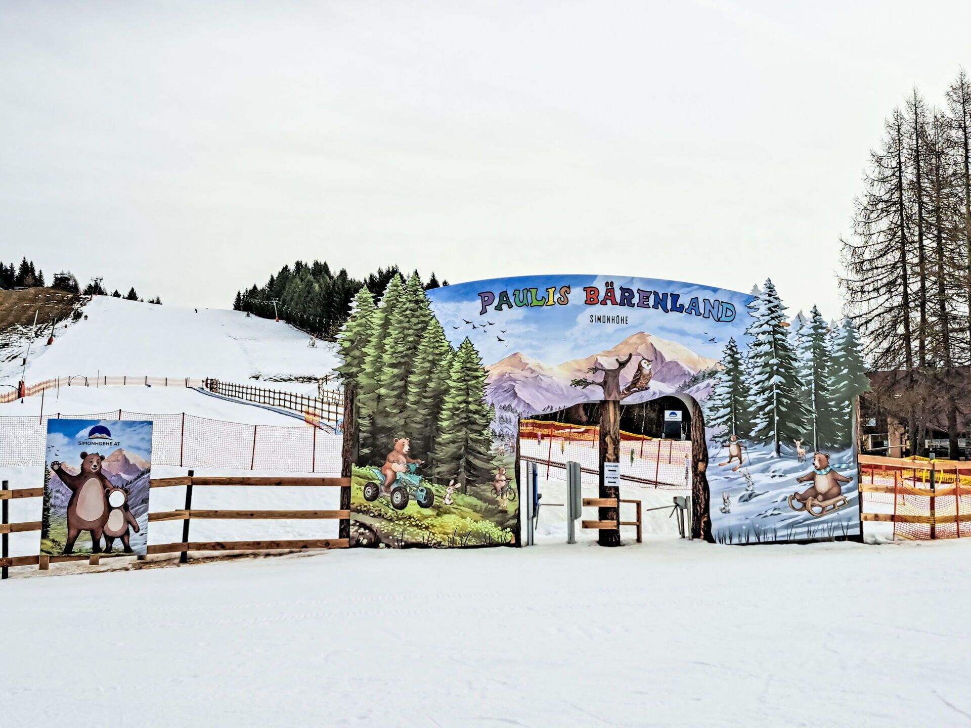 A snowy landscape with a sign reading "Paulis Bärenland" and a bear illustration.