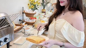 Een buffet met diverse gerechten en een persoon die een sandwich serveert.