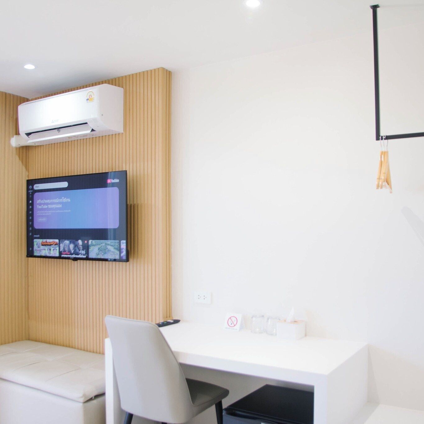 A modern room with a mounted TV, a desk, and a chair.