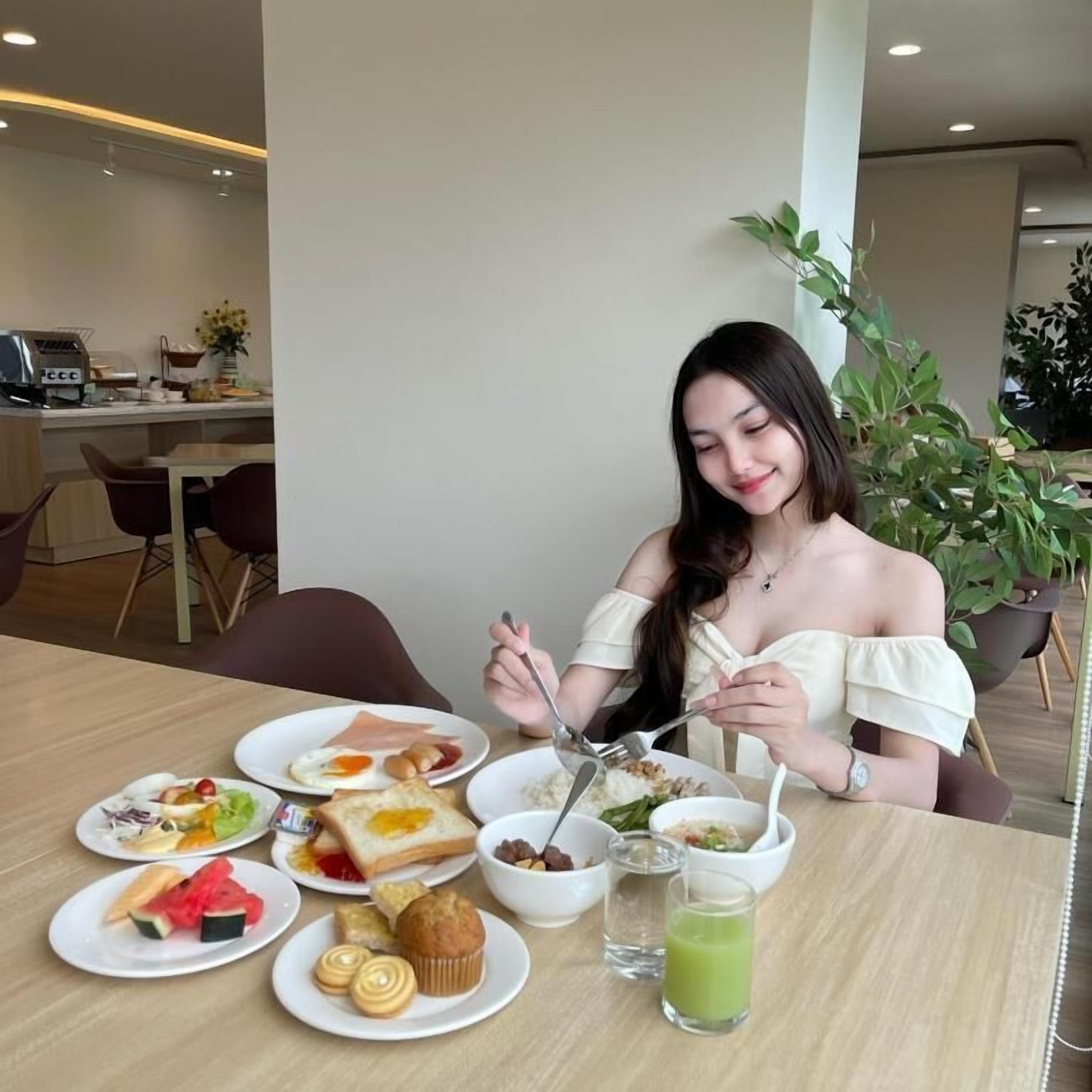 Un coin repas avec une table dressée pour un repas, comprenant des assiettes de nourriture, un muffin et une boisson verte.