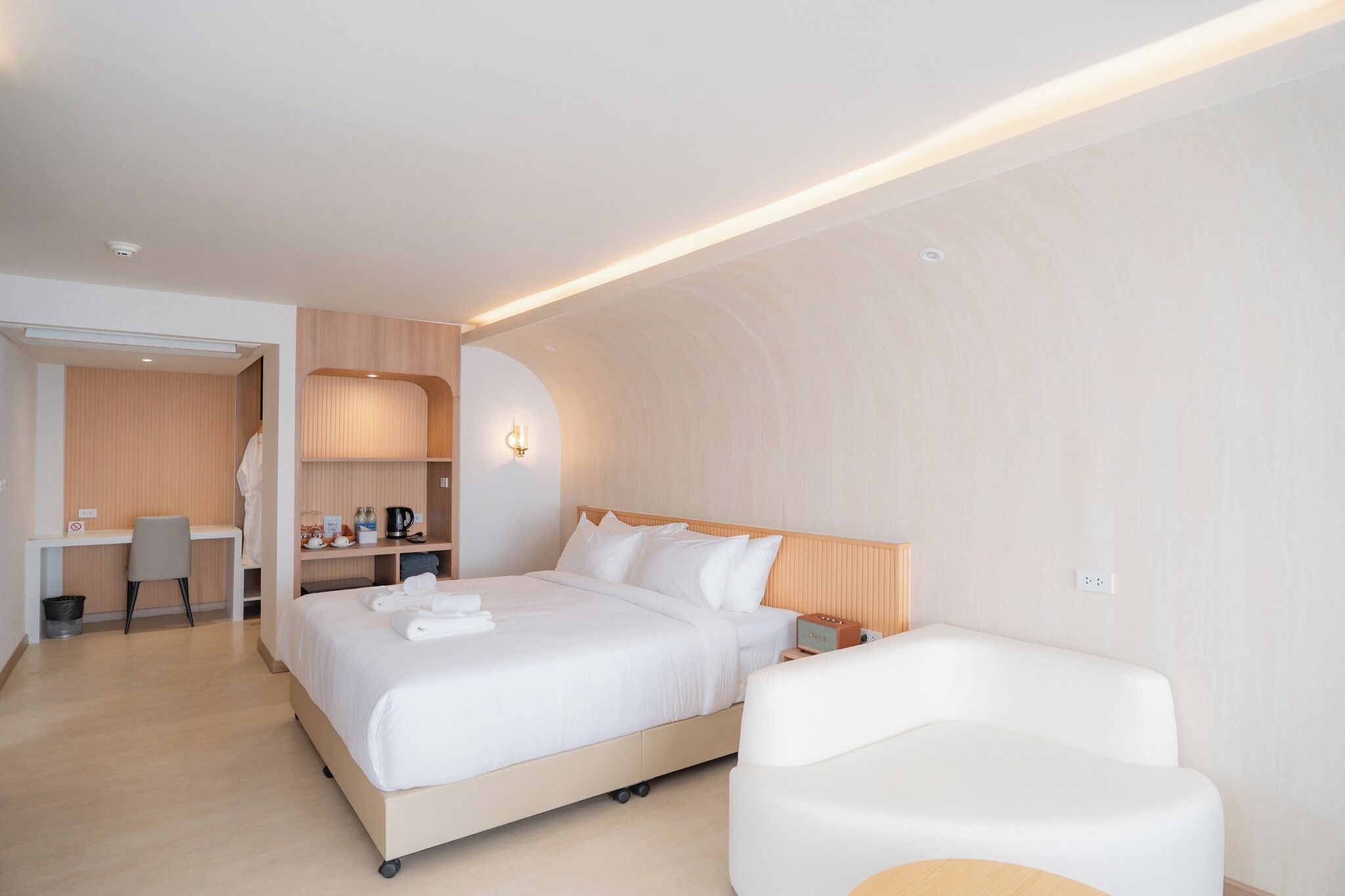 Una habitación de hotel moderna con una cama grande, un escritorio y un espacio de estar.