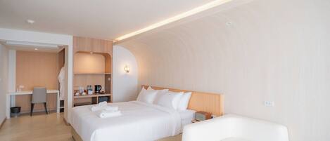 Una habitación de hotel moderna con una cama grande, un escritorio y un espacio de estar.