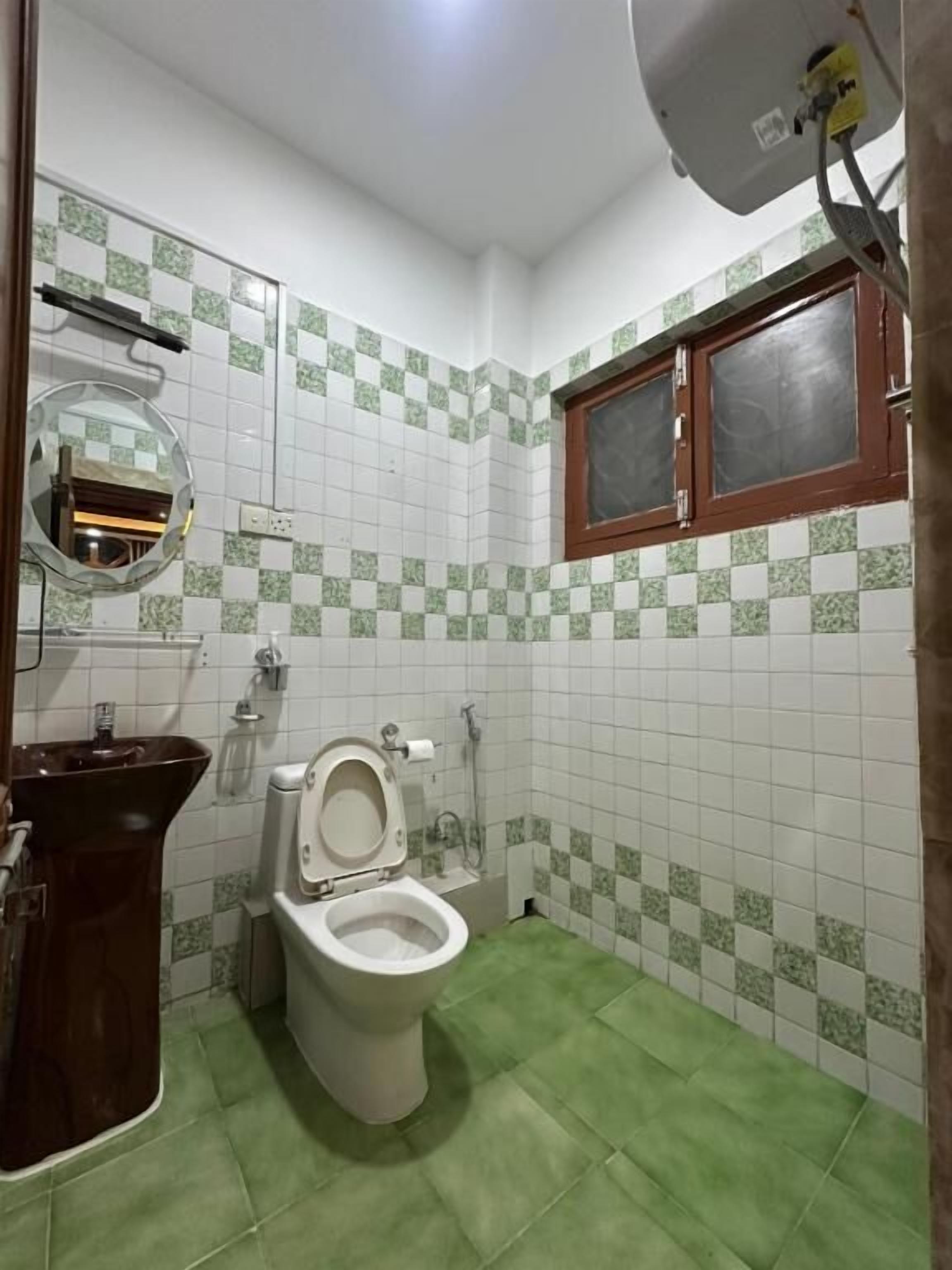A small bathroom with a toilet, sink, and a mirror.