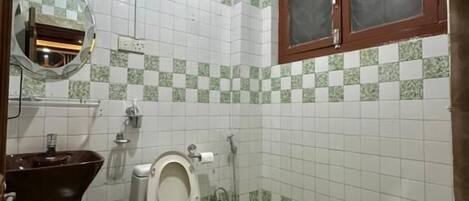 A small bathroom with a toilet, sink, and a mirror.