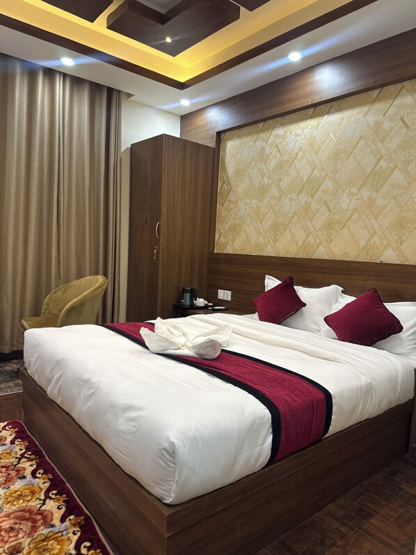 Une chambre d’hôtel avec un grand lit, une tête de lit en bois et une armoire.