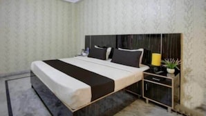Un dormitorio con cama, mesitas de noche y un velador.