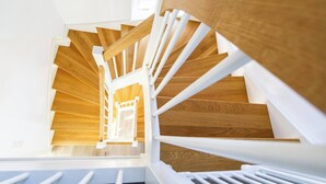 A wooden staircase with white railings and a wooden handrail. - Ferienhaus Strandhafer (Wangerooge)