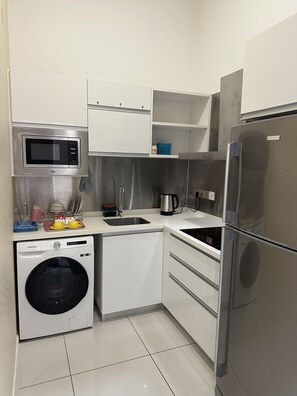 Enjoy cooking in this well-equipped kitchen with a microwave, refrigerator, and washing machine.