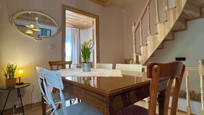Ein Essbereich mit Holztisch, Stühlen und einem Spiegel an der Wand.