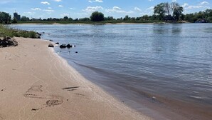 A sandy beach with footprints and a calm river. - MoJo's Tiny House on the Elbe (Bleckede)