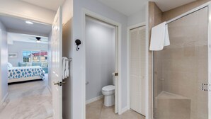 Un baño moderno con ducha, inodoro y un perchero visible para toallas.