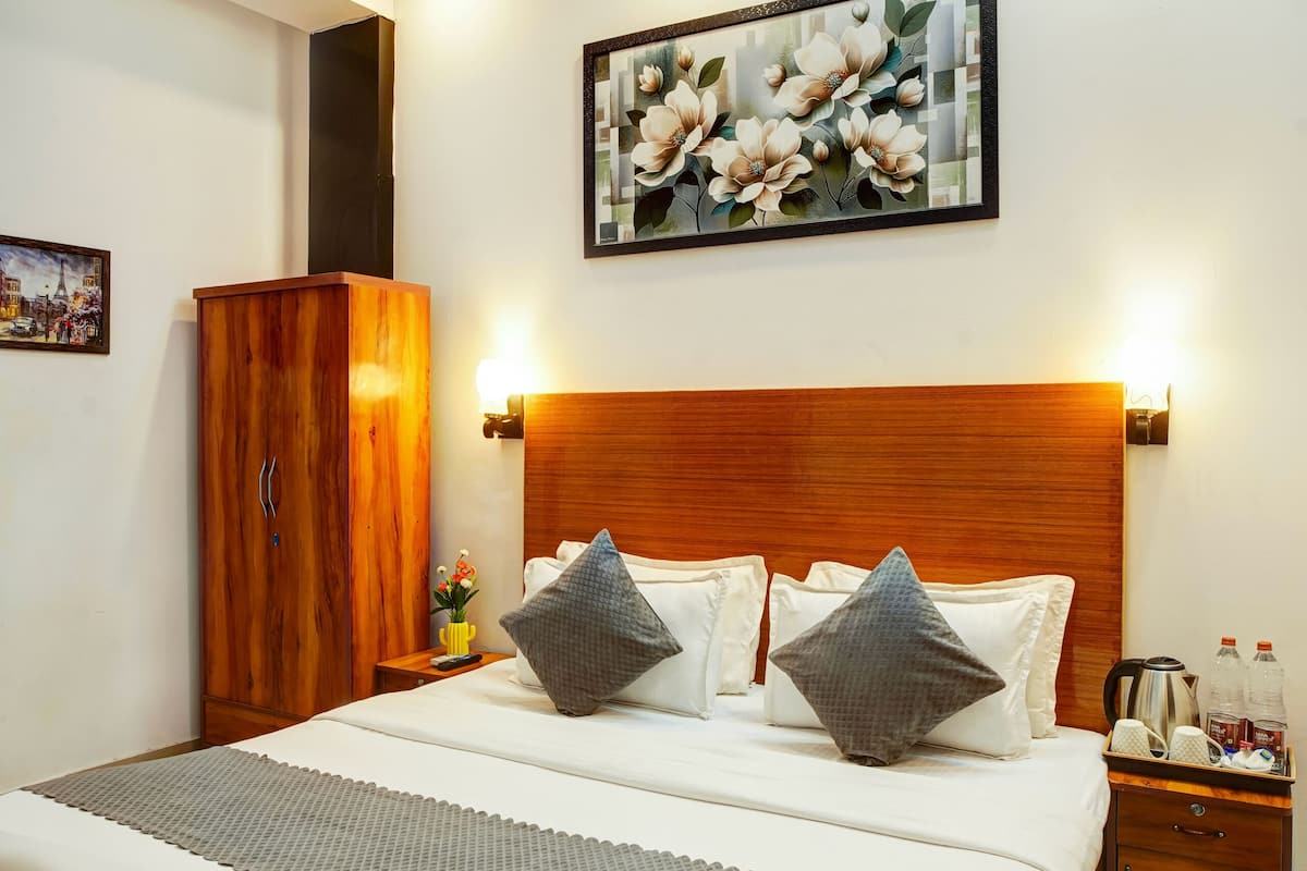 Un dormitorio moderno con una cama grande, cabecera de madera e iluminación azul en el techo.