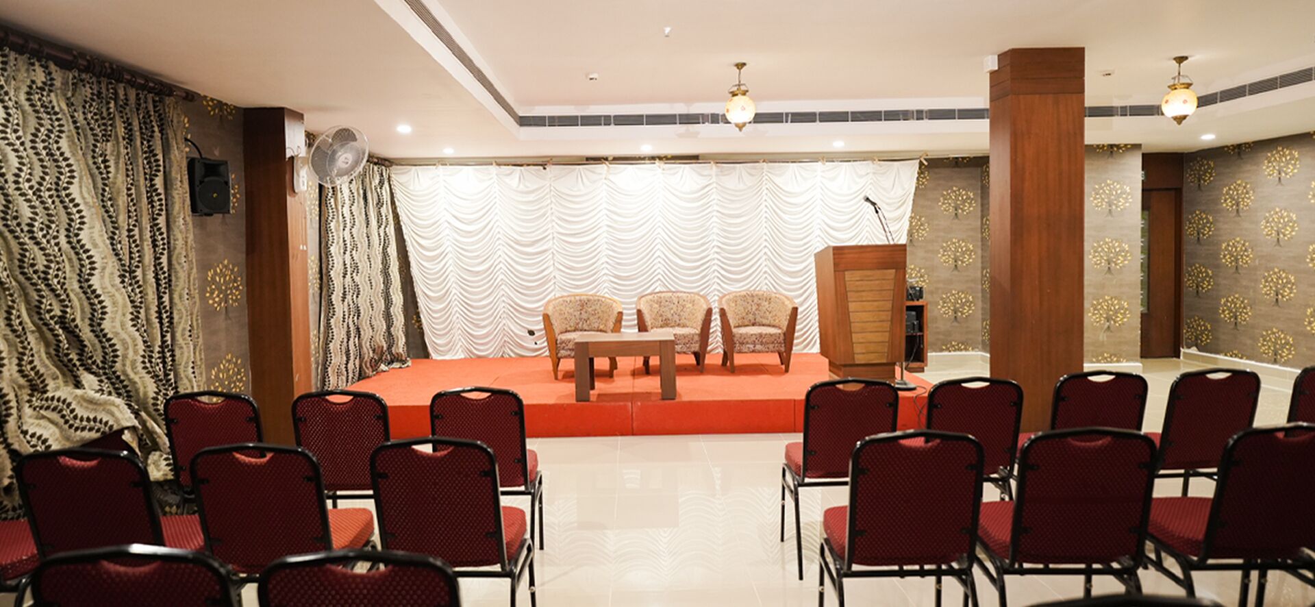 A conference room with a stage, chairs, and a podium.