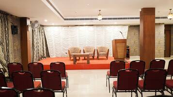 A conference room with a stage, chairs, and a podium.