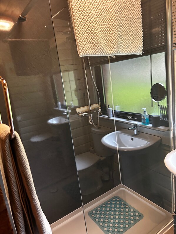 Huisje | Badkamer | Een douche, een haardroger, handdoeken