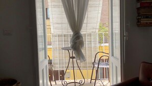 An open door with a sheer curtain, leading to a balcony with a chair and a table. - La Casa Dell'Artista - Short Term Rentals - Ferla (Ferla)