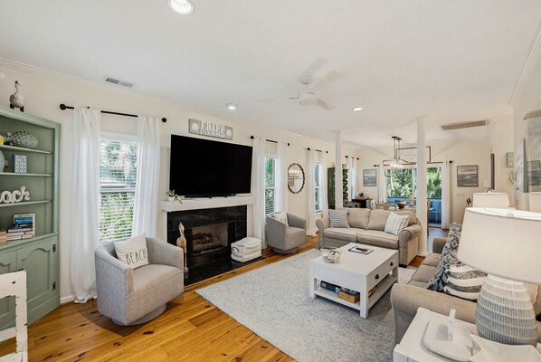A spacious living room with a fireplace, a flat-screen TV, and a comfortable seating area.