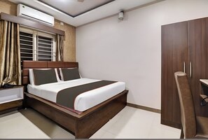 Een moderne slaapkamer met een bed, een kledingkast, een nachtkastje en een airconditioning.