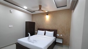 A modern bedroom with a large bed, a ceiling fan, recessed lighting, and a built-in wardrobe. - PPH Living Royal Imperial Comforts (Bengaluru)