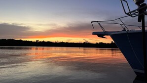 A boat with a cabin and a mast, reflecting on calm water during sunset. - Peaceful Villa near beaches to enjoy El Poblado de Boqueron. Pet-Fiendly. (Boquerón)
