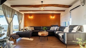 Una sala de estar moderna con un sofá modular, una mesa de centro redonda y techo de madera.
